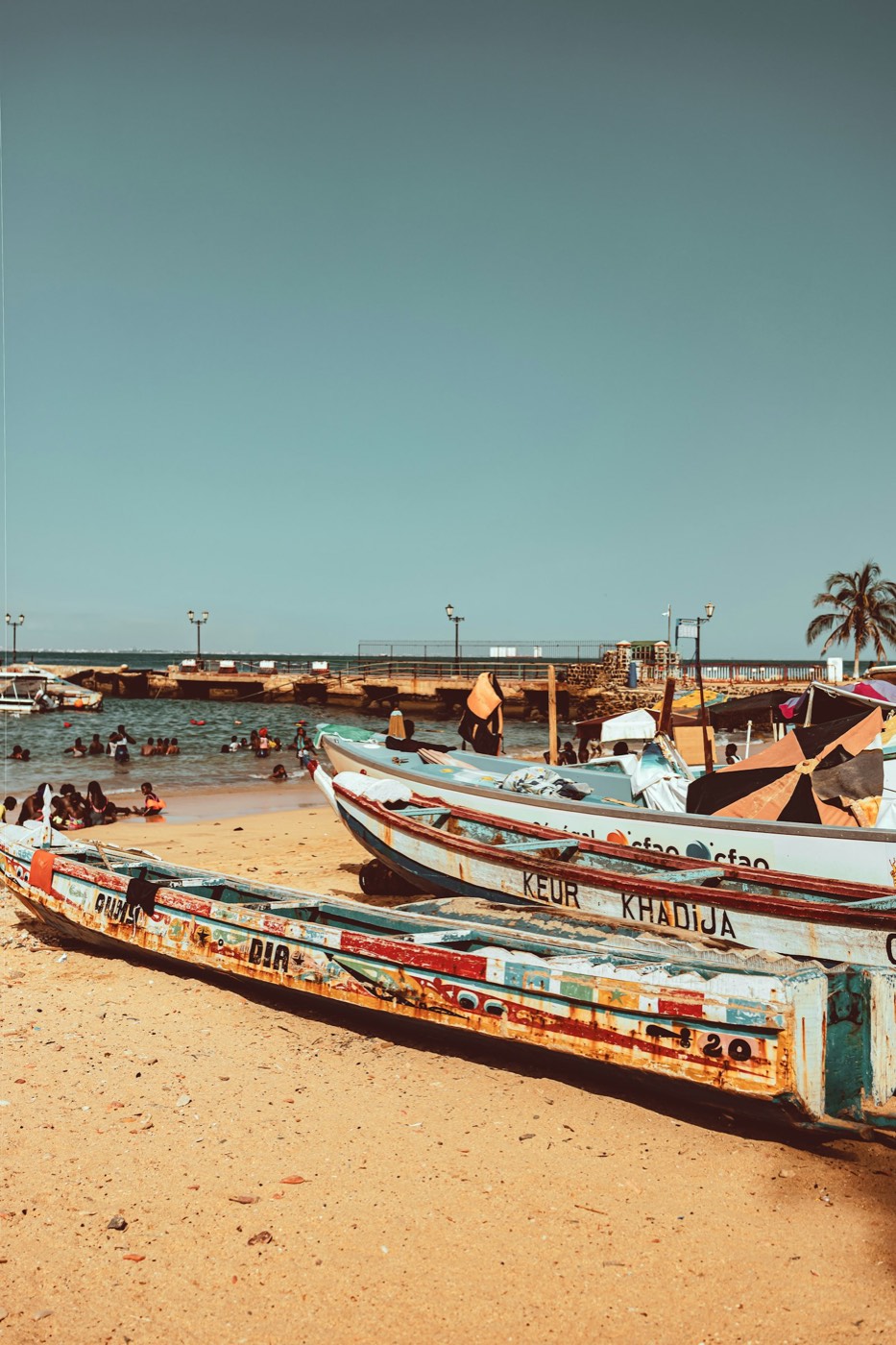 Painted wooden fishing canoes drawn up on a West African beach